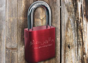 Individuelle Lasergravur auf rotem Liebesschloss